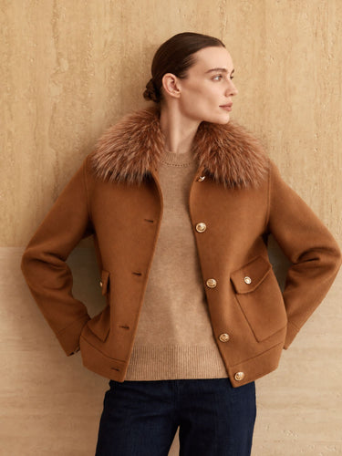 Front view of the Warm Camel cashmere bomber jacket with fur collar, worn open over a camel sweater and dark denim.