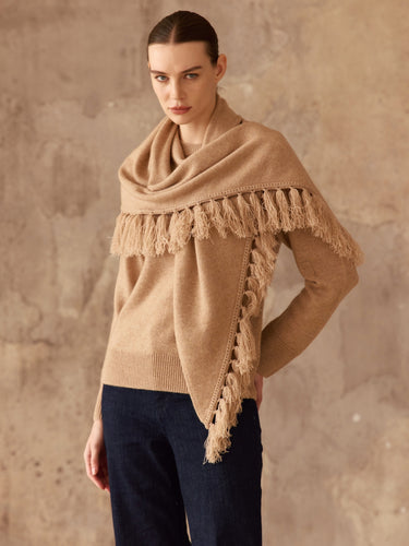Front view of the Almond cashmere sweater with its matching fringed scarf draped across the shoulders, worn with dark denim.