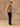 Full-length side view of the Almond cashmere sweater with matching fringed scarf, showing its relaxed fit over dark denim.