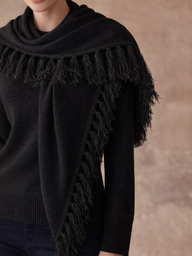 Close-up of the Jet Black cashmere sweater, showing the matching scarf’s fringe trim and the sweater’s ribbed cuffs and hem.