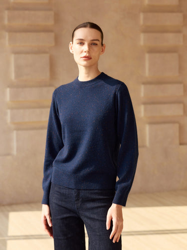 Front view of the Midnight Navy Donegal cashmere crewneck sweater, showing long sleeves and a hip-length fit over dark denim.