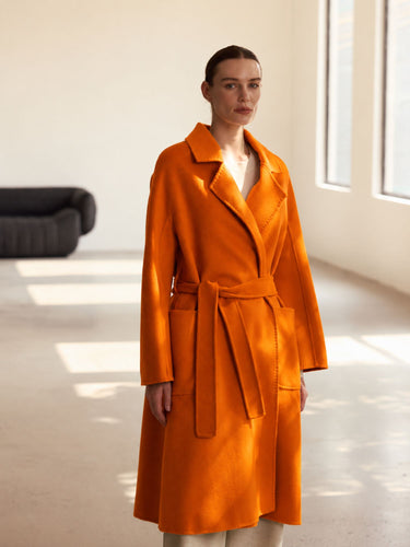 Front view of the Burnt Pumpkin Classic Cashmere Wrap Coat, showing the notched lapels, self-tie belt and generous sleeves.
