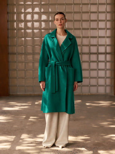 Full-length front view of the Emerald Green Classic Cashmere Wrap Coat, belted over ivory wide-leg trousers.