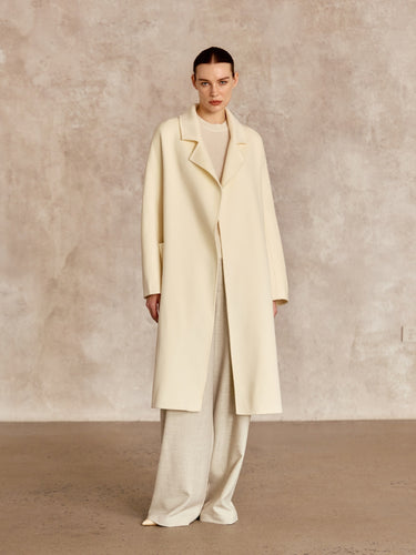 Full-length front view of the Classic Cashmere Wrap Coat in Ivory, worn open over tonal knitwear and wide-leg trousers.