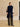 Full-length front view of the Navy and Beige Donegal cashmere travel wrap, styled with a navy sweater and grey wide-leg trousers.