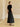 Full-length three-quarter back view of the Midnight Noir cashmere sweater, styled with a black satin midi skirt and pointed flats.