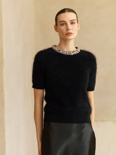 Front view of the Midnight Noir brushed cashmere short-sleeve sweater with a jeweled crew neckline, worn with a black satin skirt.