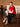 Model seated in the Ruby Red jeweled cashmere sweater, paired with a black satin midi skirt and pointed slingback heels.
