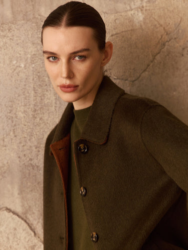 Close-up of the Soft Sage side of the Reversible Cashmere Car Coat, showing the point collar, buttons and Camel reverse inside the opening.