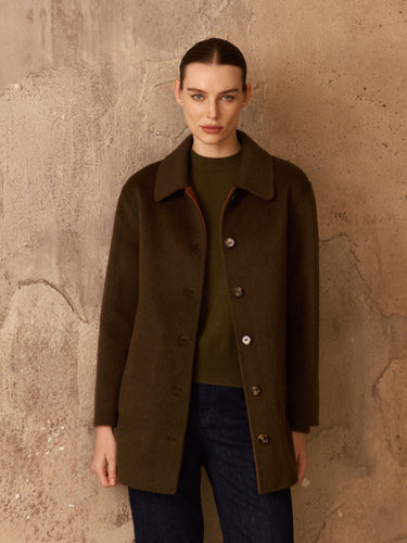 Front view of the Reversible Cashmere Car Coat worn on the Soft Sage side, showing the point collar and button front over dark denim.