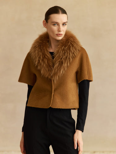 Front view of the Camel short-sleeve cashmere jacket with matching fur collar, worn over a black top and trousers.