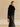 Side view of the Jet Black cashmere jacket, showing the fur collar, short sleeve and high-hip cut over a black long-sleeve top.