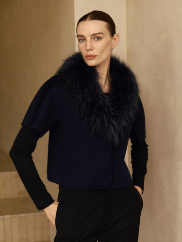 Model wearing the Midnight Navy short-sleeve cashmere jacket with fur collar over a black long-sleeve top, front view.