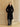 Full-length front view of the Jet Black Signature Cashmere Wrap Coat with fur collar, belted over black leather trousers.