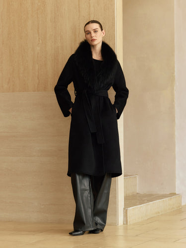 Full-length front view of the Jet Black Signature Cashmere Wrap Coat with fur collar, belted over black leather trousers.