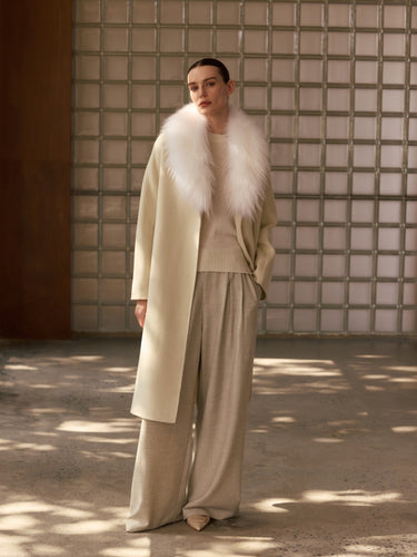 Full-length front view of the Soft Ecru Signature Cashmere Wrap Coat with white fur collar, worn open over tonal knitwear and wide-leg trousers.