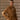 Model wearing Pissenlit’s camel wrap coat with notched lapels and a self-tie belt over an ivory sweater, with one hand in the pocket.