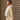 Side view of a model wearing an ivory belted coat with a wide white fur collar.