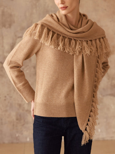 Close-up of the Almond cashmere sweater, showing the matching scarf’s fringe trim and the sweater’s ribbed cuffs and hem.
