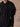 Close-up of the Jet Black cashmere sweater, showing the matching scarf’s fringe trim and the sweater’s ribbed cuffs and hem.