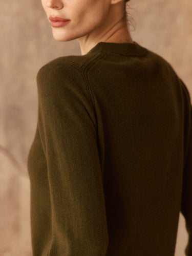 Close three-quarter back view of the Olive cashmere sweater, showing the ribbed shoulder detailing and knit texture.