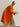 Three-quarter side view of the Burnt Pumpkin cashmere wrap coat, showing the loose silhouette, wide sleeve and belt hanging at the side.