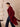 Side view of the Deep Burgundy cashmere wrap coat in motion, showing the flowing hem, side pocket and self-tie belt trailing behind.