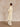 Full-length side view of the Classic Cashmere Wrap Coat in Ivory, showing its long silhouette over tonal wide-leg trousers.