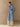 Full-length side view of the Classic Cashmere Wrap Coat in Powder Blue, belted with the model’s hand in a side pocket.