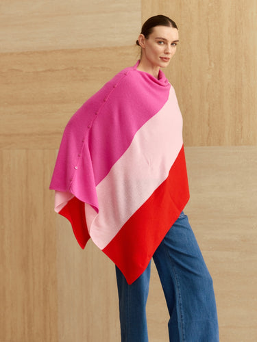 Model wearing the Rose Multi colorblock cashmere topper with an asymmetric pointed drape and tonal buttons along the shoulder.