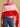 Closer front view of the Rose Multi cashmere topper draped across the shoulders, showing three horizontal bands of pink, pale pink and red.