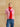 Rose Multi cashmere topper wrapped as a scarf, showing pink and red panels over a pink short-sleeve sweater and blue denim.