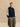 Front view of the Midnight Navy and Beige Donegal cashmere travel wrap draped over a navy sweater and grey trousers.