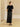 Full-length front view of the Midnight Noir jeweled cashmere sweater, paired with a black satin midi skirt and pointed flats.