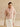 Full-length back view of the Blush cashmere jacket with fur collar, worn with an ivory satin midi skirt and heels.