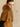 Close three-quarter view of the Camel cashmere jacket, showing the fur collar and generous short sleeve over a black top.