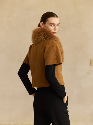 Three-quarter back view of the Camel short-sleeve cashmere jacket, showing the fur collar and high-hip cut.