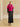 Full-length front view of the Glow Pink short-sleeve cashmere jacket with fur collar, paired with a black satin midi skirt.