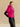 Three-quarter side view of the Glow Pink cashmere jacket, showing the matching fur collar, short sleeves and high-hip cut.