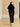 Full-length back view of the Jet Black short-sleeve cashmere jacket with fur collar, worn with a satin midi skirt and heeled sandals.