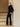 Full-length three-quarter view of the Midnight Navy cashmere jacket with fur collar, styled with black trousers and heeled sandals.