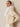 Side view of the Soft Ivory cashmere jacket, showing the fur collar, short sleeves and rounded front edge.