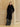 Full-length front view of the Jet Black Signature Cashmere Wrap Coat, tied at the waist with the model’s hands in the side pockets.