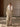 Full-length front view of the Soft Ecru Signature Cashmere Wrap Coat with white fur collar, worn open over tonal knitwear and wide-leg trousers.